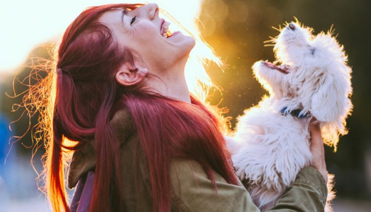 Une femme rit avec son chien