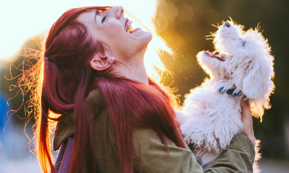 Une femme rit avec son chien